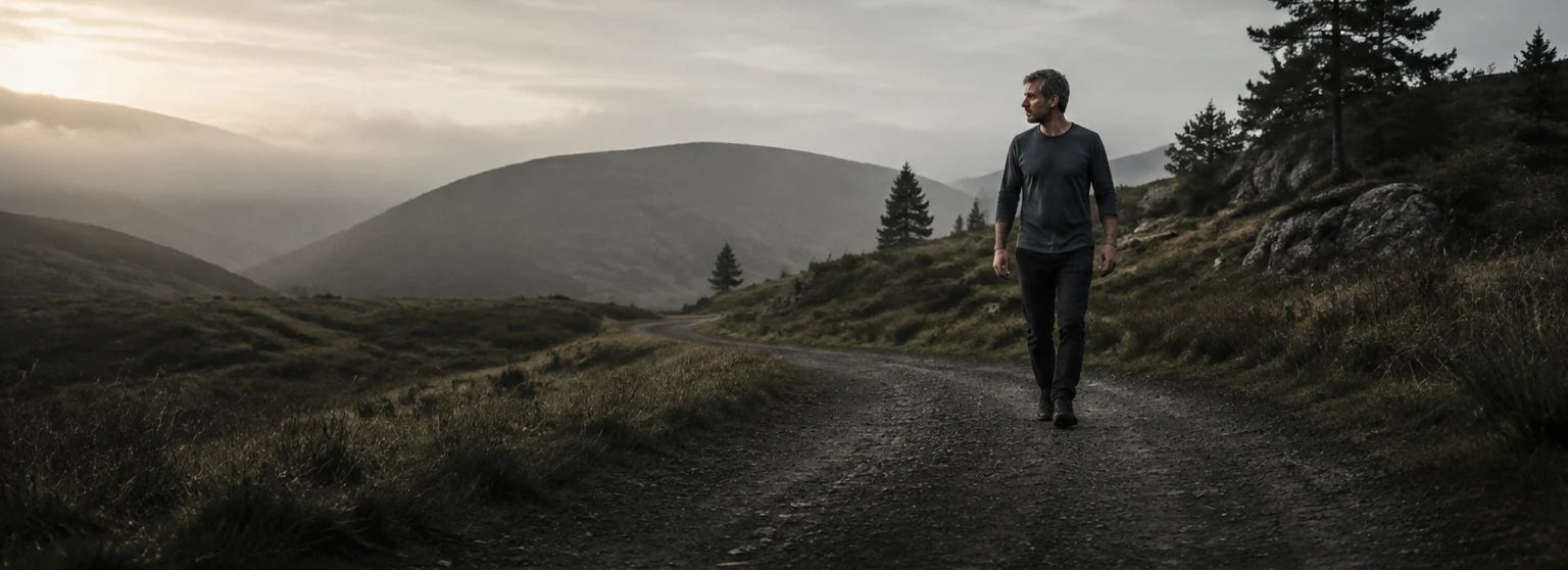 Illustration d’ambiance générée par IA : un homme marche sur un sentier vallonné.